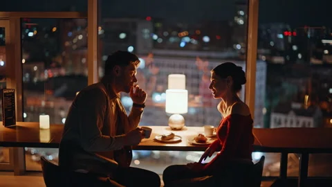 Romantic couple sitting dark restaurant at panoramic window with night city view Stock Footage 340110373