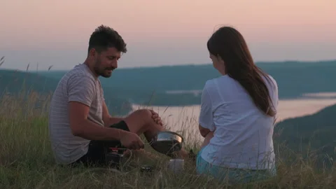 The romantic couple sitting on mountain top and drinking tea. slow motion Stock Footage 159596161