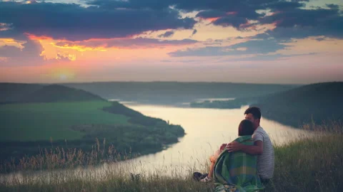 The romantic couple sitting on the mountain top above the scenic river Stock Footage 159683021