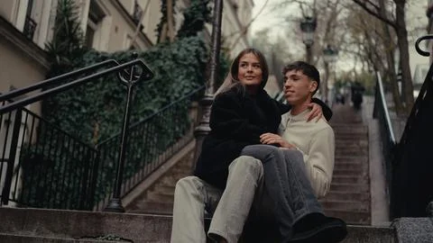 Romantic Couple Sitting On Stone Steps In Montmartre Paris France Embracing A Stock Photos