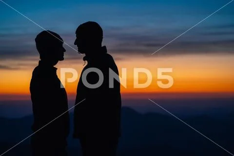 The romantic couple standing on the mountain landscape background with a suns Stock Photos