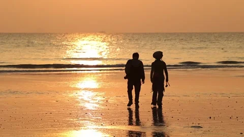 A romantic couple strolling along the sunset beach Video stock 235653370