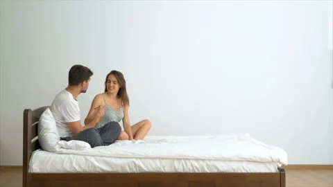 The romantic couple talking in the bed on the white wall background Stock Footage 90101157