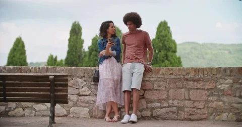 Romantic couple using smartphone in rural town of Assisi.Portrait medium shot Stockbeeldmateriaal 114385596
