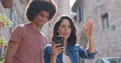 Romantic couple using smartphone to search amenities or landmarks in rural town 動画素材 107626277