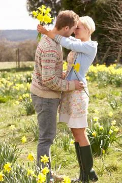 Romantic couple walking amongst spring daffodils Stock Photos