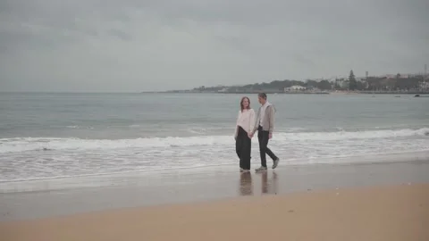Romantic couple walking on beach on cloudy day Stock Footage 304631665