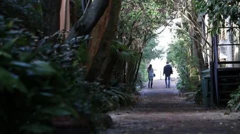 Romantic couple walking down narrow garden pathway Stock Footage 45581235