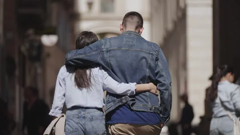 Romantic couple walking down a Rome city street embracing during a sunny day Stock-Footage 305946341