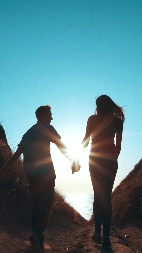 The romantic couple walking down to the sea shore. slow motion Stock Footage 242239519