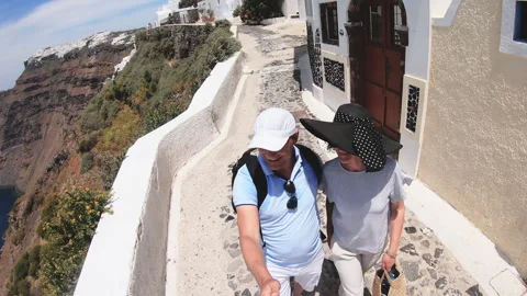 Romantic couple walking down a stone walkway on Santorini island sightseeing  Stock Footage 320471933