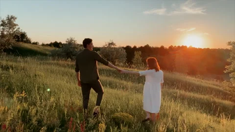 Romantic couple walking on the field in the evening sunset Video stock 147532287
