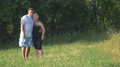 Romantic couple walking grass field playing sunset happy holding dog woman man  Stock Footage 27963272
