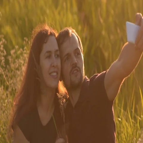 Romantic couple walking in the Park at sunset and makes a selfie 動画素材 69550341