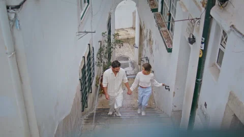 Romantic couple walking stairs up tiny street. Happy pair enjoying summer date Stock Footage 259112247
