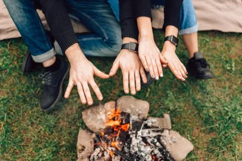 Romantic couple warming their hands over bonfire Fotos Stock