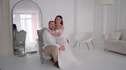 Romantic couple in wedding attire posing in elegant white room, moment of love. Stock Footage 307599065