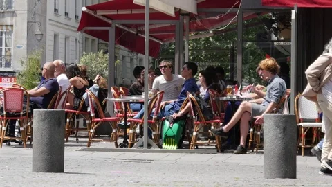 Romantic cozy street cafe tables with people sit and communicate in city center Stock Footage