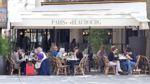 Romantic cozy street restaurant tables with people eat and communicate in Paris Stock Footage