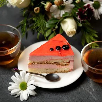 Romantic dessert. Slice of red cake on saucer, Two cups of tea and bouquet of Stock Photos