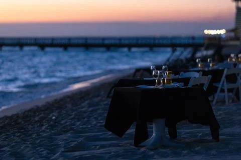 Romantic dinner on the background of sunset on the seashore Stock Photos
