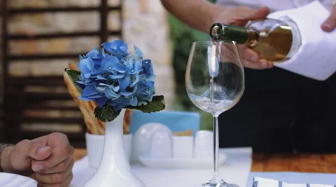 Romantic dinner date pouring white wine and clinking glasses Stock Footage 56717097