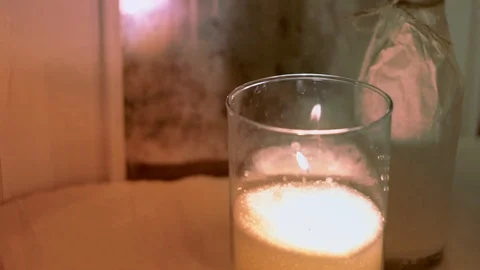 Romantic dinner decoration: white burning candle in glass vase in an old cafe 스톡 동영상 107777652