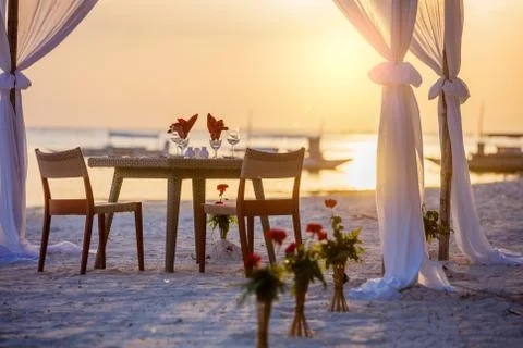 Romantic dinner setting on the beach at sunset 写真素材