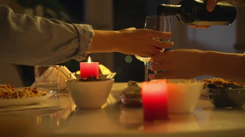 Romantic dinner setting with candlelight and wine sharing Stock Footage 303651099
