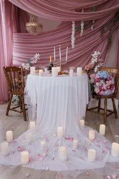 Romantic Dinner Setup: Rose Pink Backdrop, Candlelight, Floral Table, Intim.. Stock Photos