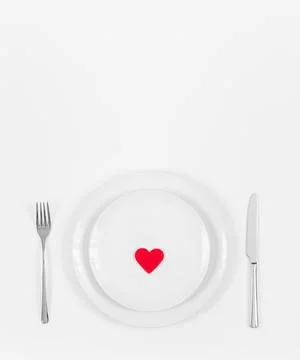 Romantic dinner table. Festive table setting with a red heart in a plate Stock Photos