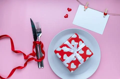 Romantic dinner table. Gift or present box, greeting card, mini heart, plate, Stock Photos