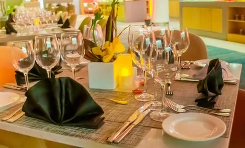 Romantic dinner table setup decoration with candle light in a restaurant. Sel Stock Photos