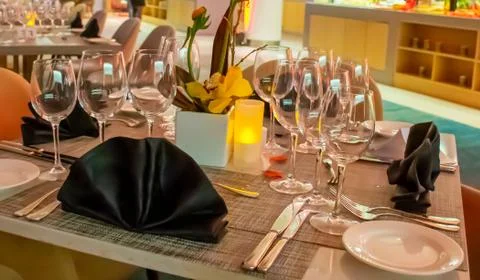 Romantic dinner table setup decoration with candle light in a restaurant. Sel Stock Photos