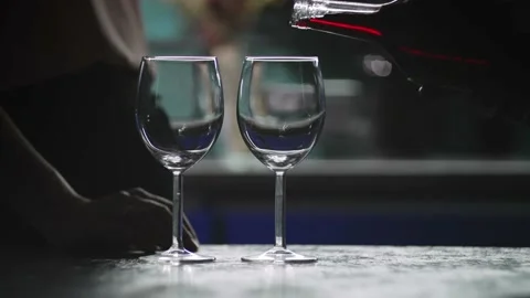 A romantic evening at home in the kitchen, a man pours wine into glasses. Stock Footage 214324244
