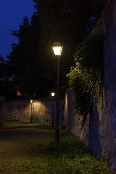 Romantic evening view of an ancient cobblestone street with warm lantern li.. 스톡 사진