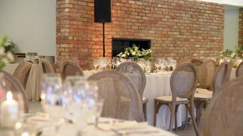 Romantic Event Table Setting With Elegant Glassware and Rustic Brick Wall Decor Stock Footage 335972376