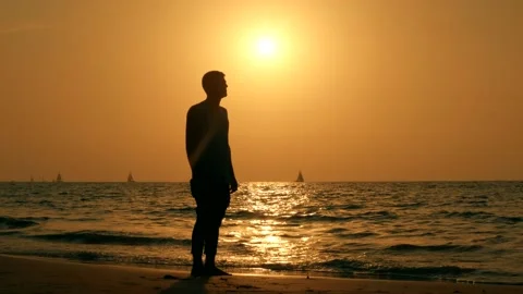 Romantic man on the beach at sunset background thinking about love Stock Footage 139498028