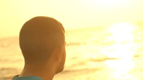 Romantic man on the beach at sunset background thinking about love Stock Footage 139498062