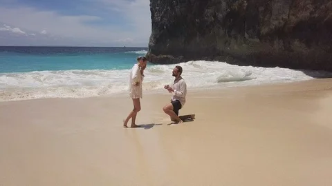 Romantic man standing on one knee and doing proposal to his beautiful girlfriend Stock Footage 125226864