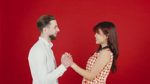 A romantic multiracial couple embracing affectionately while posing against a vi Stock Footage 296394593