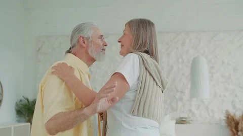 Romantic old couple dancing in the living room, the loving husband holds the Vídeos de archivo 224538430