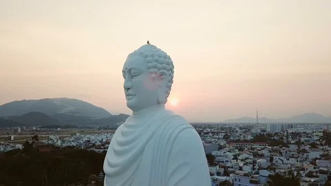 Romantic orange sunset drone orbit large Buddha statue Vietnam hill temple  Stock Footage 107122165