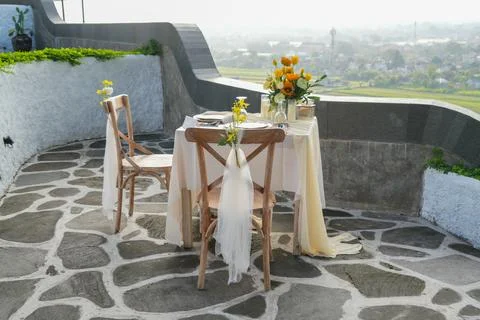 Romantic outdoor dining table for two decorated with yellow flowers. Stock-Fotos