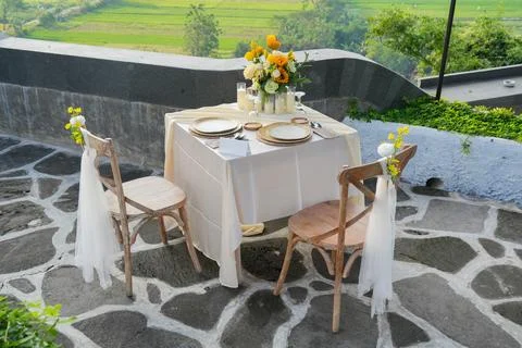 Romantic outdoor dining table for two decorated with yellow flowers. 스톡 사진