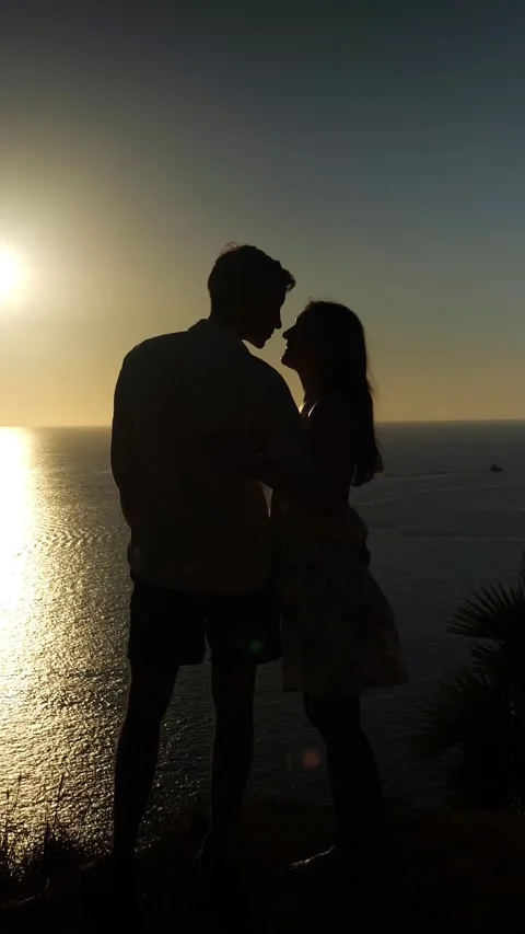 Romantic Pair Holding Hands At Dusk Near Sea. Silhouetted Lovers Share Tender Stock Footage 335502975