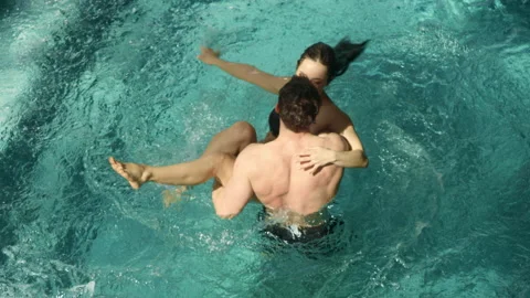 Romantic pair hugging in pool indoors. Man holding woman in arms in thermal pool Video stock 141407089