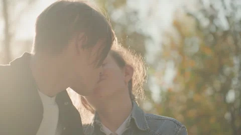 Romantic park scene. Sunlit couple with gentle smiles in natural setting. Serene Stock Footage 337730626