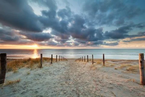 Romantic path to sand beach at sunset Stock Photos