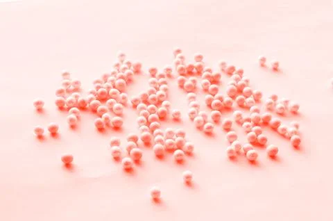 Romantic pattern of pink tinted beads scattered on a soft pink background, fe Stock Photos